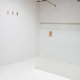 Minimalistische badkamer met inloopdouche en beton ciré wanden en vloer.