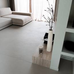 Moderne woonkamer met beton ciré vloer en strakke wandafwerking.